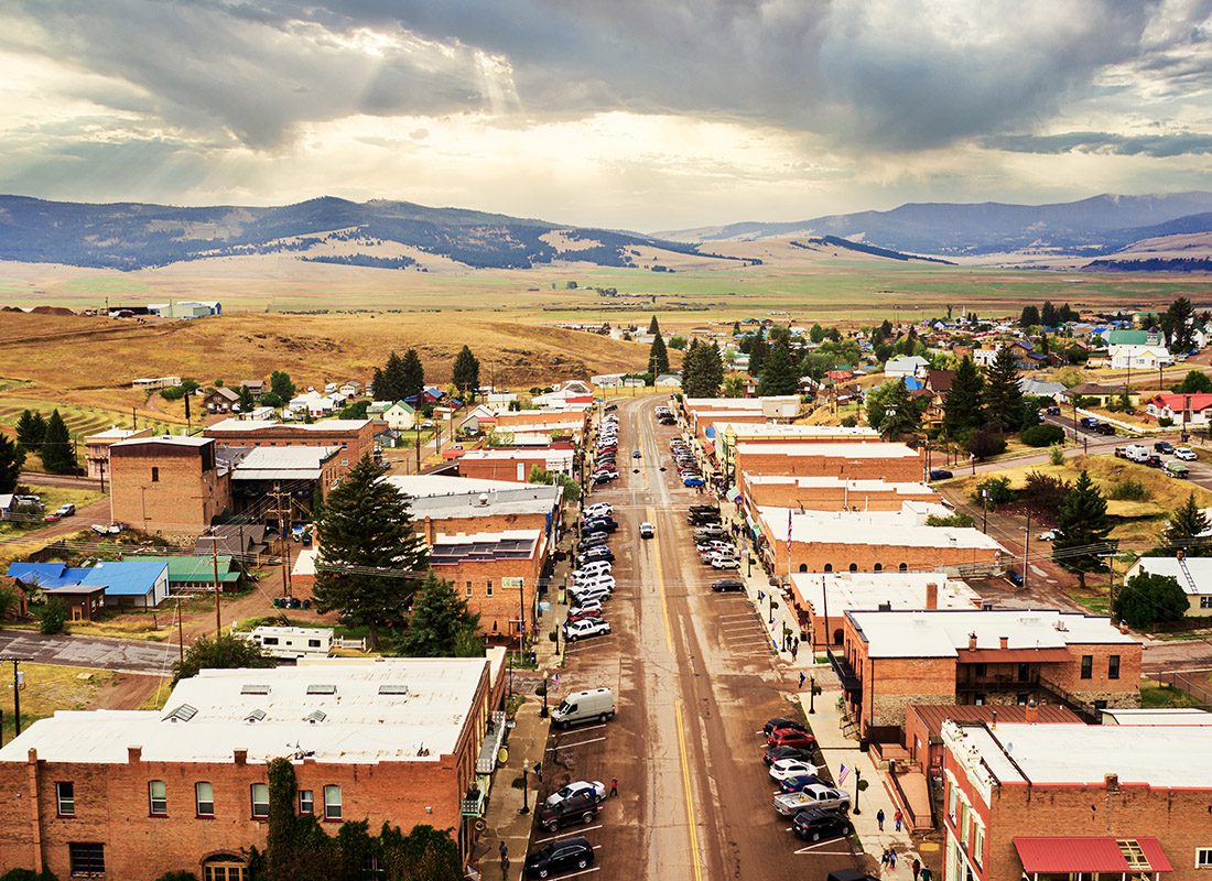 Ennis, MT - Aerial View of Broadway Street in Philipsburg, Montana With Mountains in the Background on a Cloudy Day